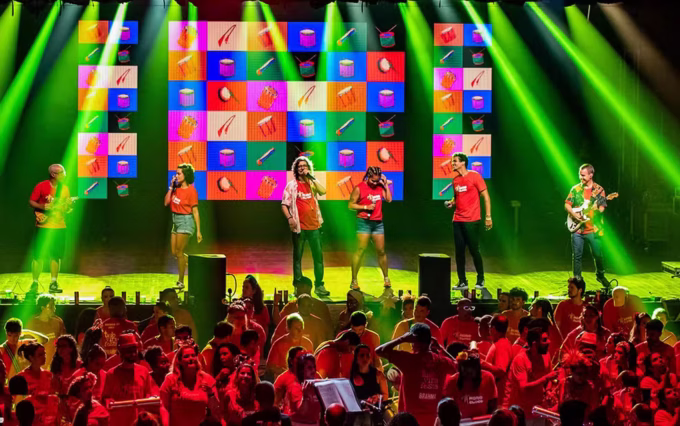 Grupo Monobloco se apresenta no palco durante show musical.